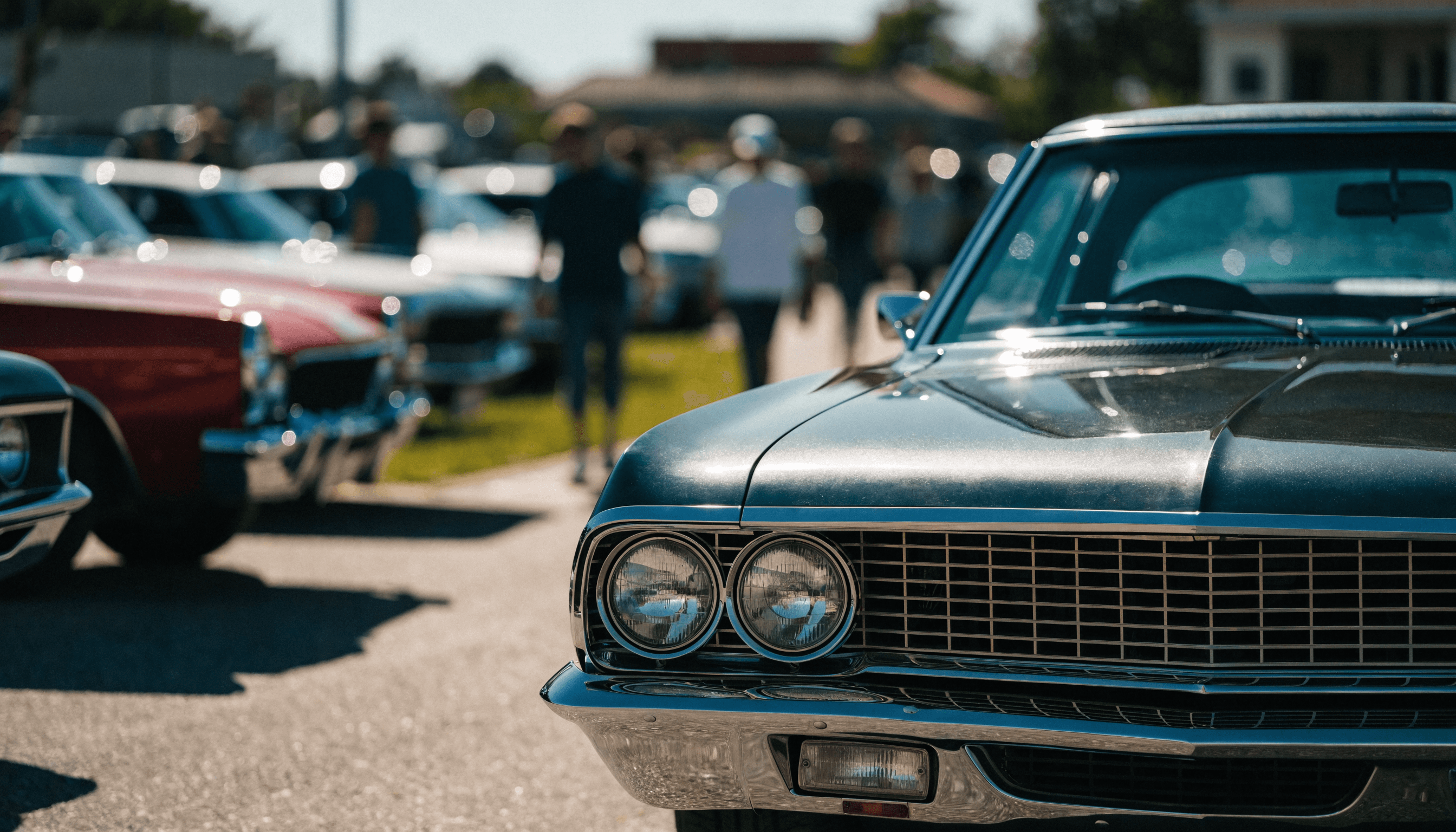 A classic car parked at an outdoor car show on a sunny day