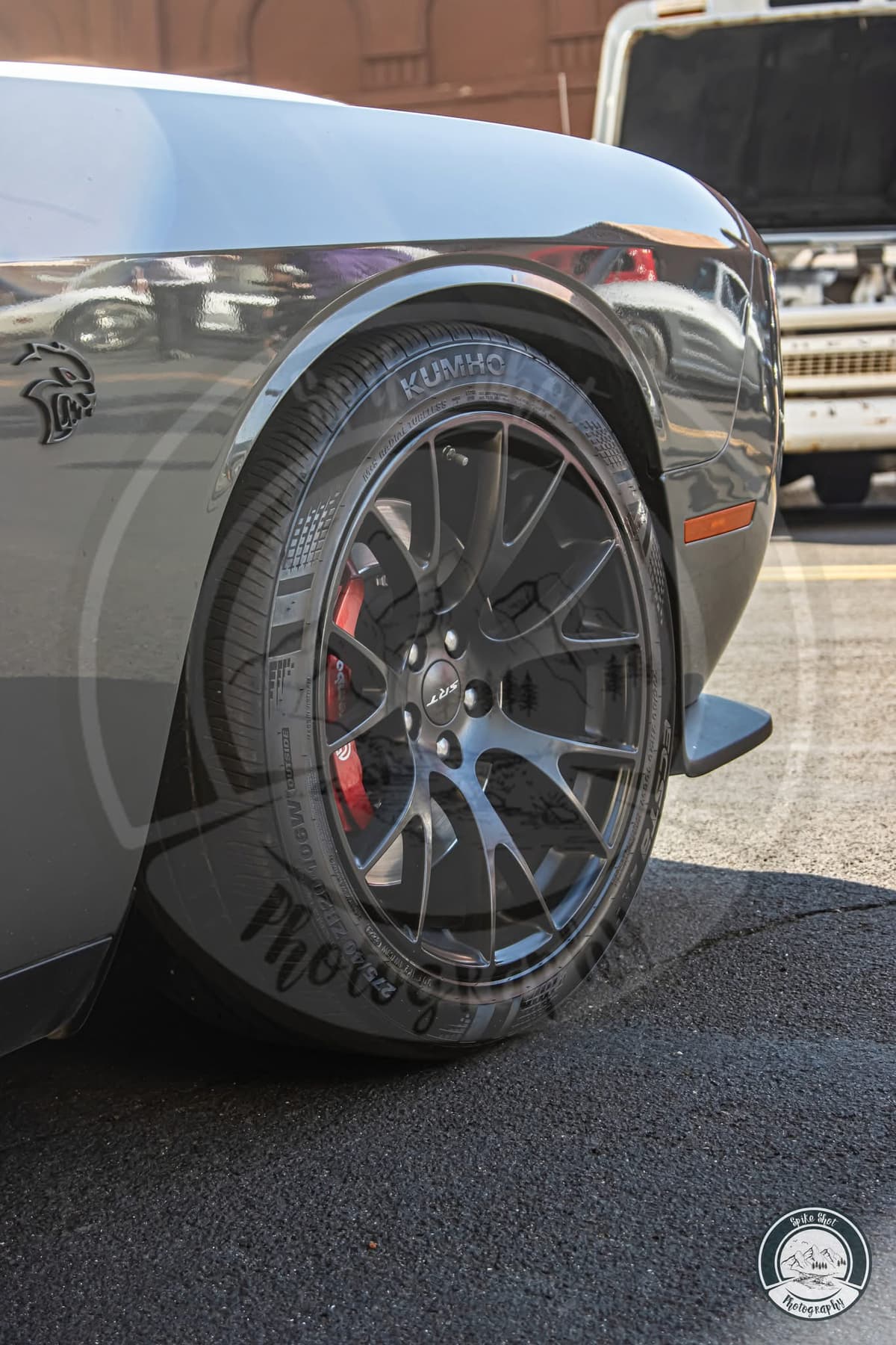 Another angle on a factory wheel, red brake caliper and Hellcat fender badge