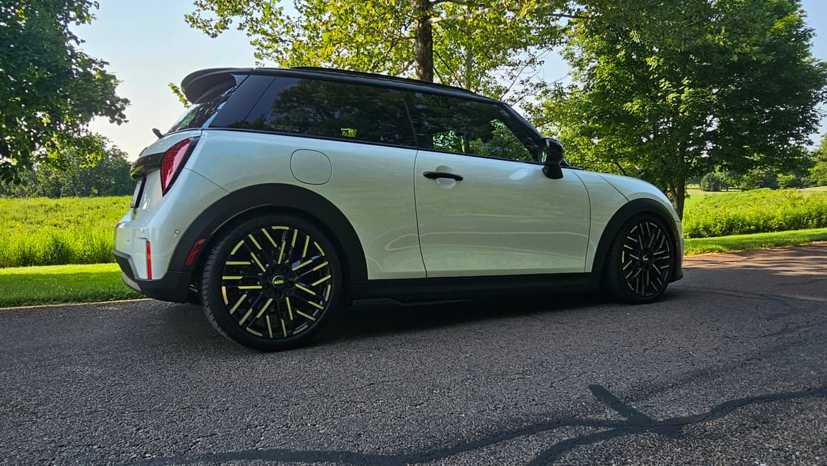 Side profile of the Mini on pavement showing the lime-green Team Dynamics wheels and side skirts